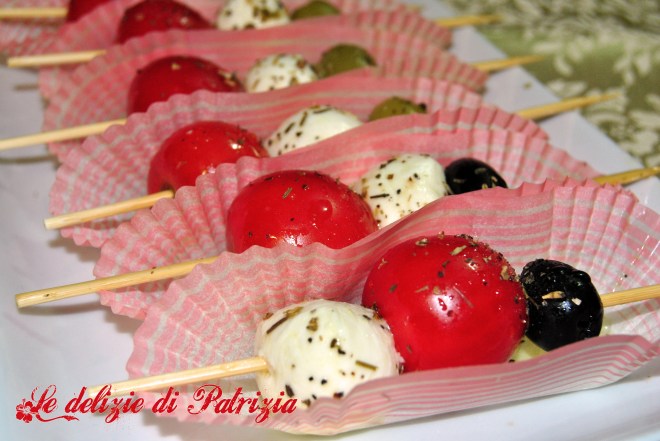 Spiedini di mozzarelline, olive, pomodori e origano
